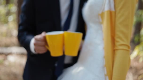 Молодые люди держат в руках желтые чашки — стоковое видео