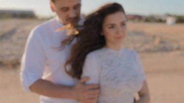 Beyaz genç adam ve kadın sahilde kucaklamak