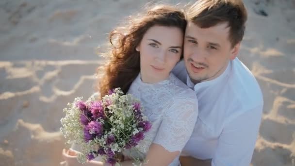 Les jeunes en vêtements légers assis sur le sable — Video