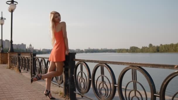 Молодая женщина позирует фотографу у реки — стоковое видео