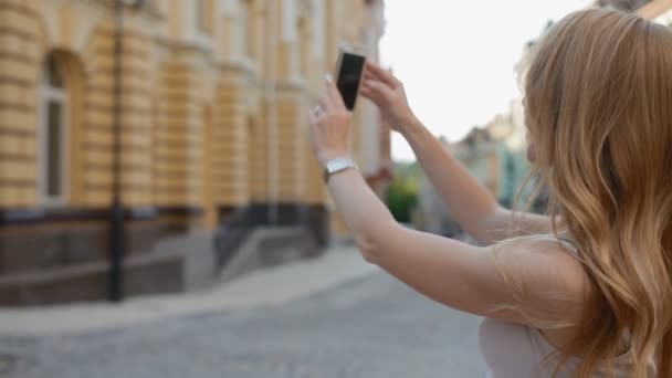 Kvinnan ta bilder av byggnader med mobiltelefon — Stockvideo