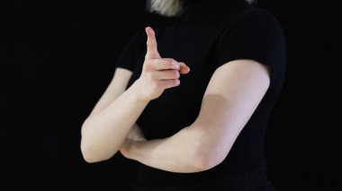 Kara Arkaplan, Dikkat ve Yönlendirme kavramı üzerine Minimal Stüdyo Ayarı 'nda Kendinden emin Kadın El Gösterme Yönlendirmesi. Yüksek kalite fotoğraf