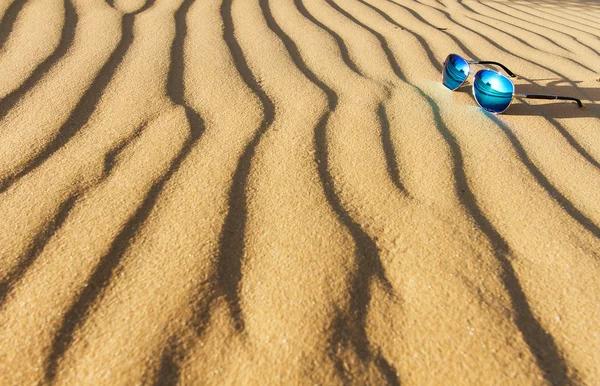 Sunglasses on the sand in the desert. — Stock Photo, Image