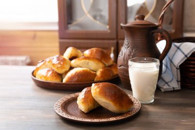 Tahta bir masaya bir kupa sütle doldurulmuş taşralı turtalar.
