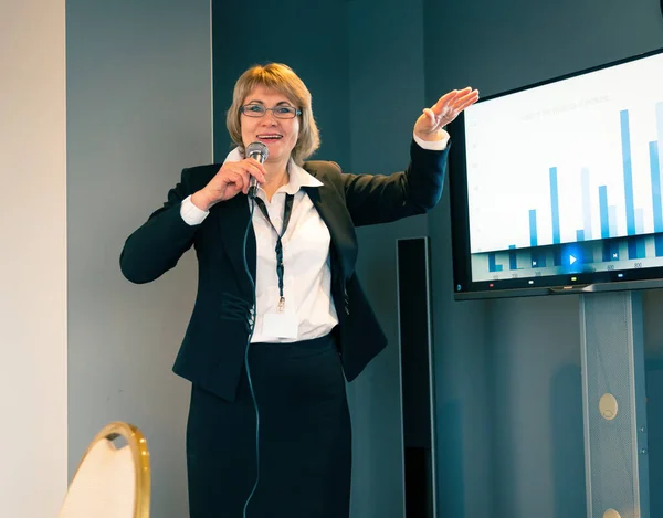 A business woman makes a presentation in a conference room with training. Middle-aged woman coaching