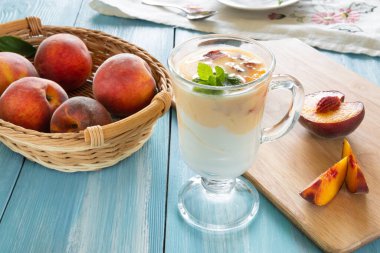 Şeftalili yoğurt ve masada bir kaşık taze meyve. Sağlıklı kahvaltı. Vejetaryenlik
