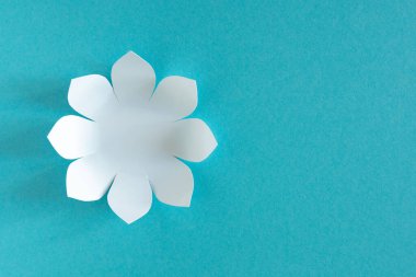 Mavi arka planda beyaz kağıt çiçekler olan kart. Boşluğu kopyala