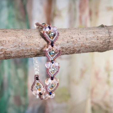 Arka planda eller tarafından yapılan farklı renkte boncuklardan yapılmış bilezik.