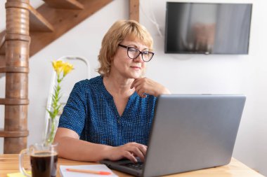 Masada çalışan orta yaşlı bir kadın dizüstü bilgisayara bakıyor. Haberleri okuyor, sosyal ağlardan arkadaşlarıyla iletişim kuruyor ve film izliyor..