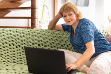 Masada çalışan orta yaşlı bir kadın dizüstü bilgisayara bakıyor. Haberleri okuyor, sosyal ağlardan arkadaşlarıyla iletişim kuruyor ve film izliyor..