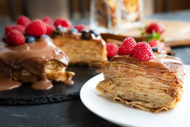 Koyu arkaplanda çikolata, ahududu ve yaban mersinli krep..