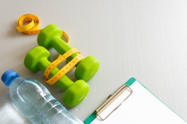 Gri arka planda dambıllar. Sağlıklı yaşam tarzı kavramı.