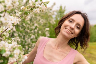Çiçek açan bir bahar ağacının yanında bir kadın. Romantik mutlu ruh hali.
