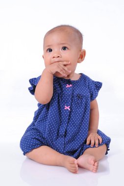 Güzel, güzel, mavi kız tişörtü, elini çiğniyor, beyaz arka planda soyutlanmış.