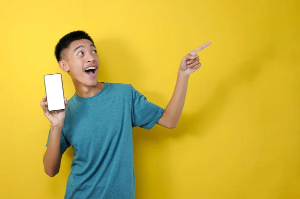 Feliz Joven Asiático Sonriente Mostrando Teléfono Móvil Con Otra Mano —  Fotos de Stock