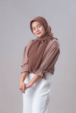 Sarışın, genç, tatlı Asyalı Müslüman kadın gri arka plan stüdyo resmine izole edilmiş gibi poz veriyor.