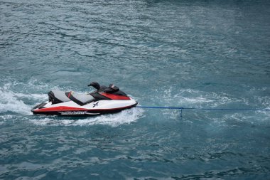 İnsan olmadan denizde kırmızı ve beyaz jet ski, yan görüş. Hareket konseptine hazır olmak. Yaz tatili. Yalnız su motosikleti mavi denizde yüzer.