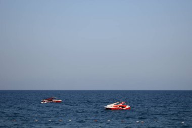 Deniz dalgalarında iki motorlu tekneyle güzel bir sahilden deniz manzarası. Mavi Ufuk ve Deniz