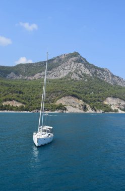 Akdeniz 'de bir dağ sırasının arka planında Kaplumbağa Adası yakınlarında yelken açan yelkenli. Seyahat konsepti. Antalya hindisi. 26 Eylül 2020