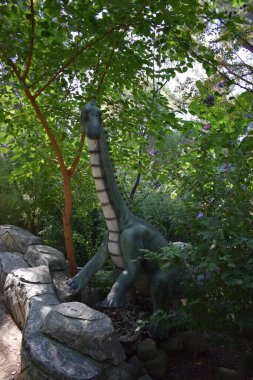 Orman parkındaki dinozor heykeli arka plan için doğada. Ormandaki küçük dinozor heykelleri. Türkiye 'de Dinopark, Goynuk.