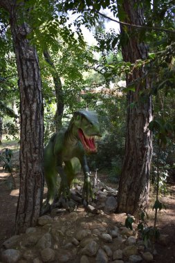 Sinir bozucu. 110 milyon yıl önce, Kretase döneminin başlarında. Dinopark 'ta. Orman parkındaki dinozor heykeli arka plan için doğada. Aç büyük tahriş edicinin gerçekçi modeli. Türkiye 'de Dinopark, Goynuk.