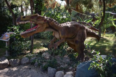 Sinir bozucu. 110 milyon yıl önce, Kretase döneminin başlarında. Dinopark 'ta. Orman parkındaki dinozor heykeli arka plan için doğada. Aç büyük tahriş edicinin gerçekçi modeli. Türkiye 'de Dinopark, Goynuk.