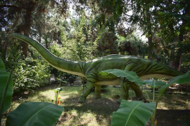 Orman parkındaki dinozor heykeli arka plan için doğada. Omeisaurus - Ortanca Jurassic 171-161 milyon yıl önce. Türkiye 'de Dinopark, Goynuk.