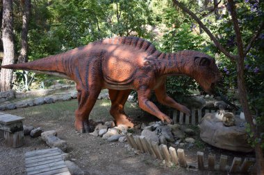 Orman parkındaki dinozor heykeli arka plan için doğada. Yuvasının yakınında yumurtaları olan gerçekçi bir dinozor modeli. Türkiye 'de Dinopark, Goynuk. Dinozor modeli Maiasaura yumurta dolu.