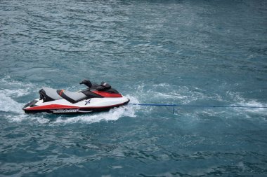 İnsan olmadan denizde kırmızı ve beyaz jet ski, yan görüş. Hareket konseptine hazır olmak. Yaz tatili. Yalnız su motosikleti mavi denizde yüzer.