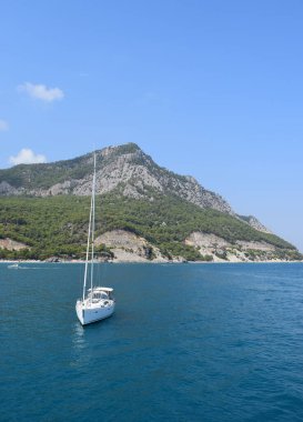 Akdeniz 'de bir dağ sırasının arka planında Kaplumbağa Adası yakınlarında yelken açan yelkenli. Seyahat konsepti. Türkiye 'nin Antalya kentinde lüks teknesi olan güzel kıyı manzarası.