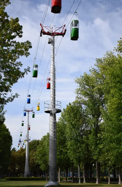 Brightly colored cable cars carry tourists. Running on wires supported by steel pylons, it is the longest cable car route. gondola cabins suspended cable car in city park.