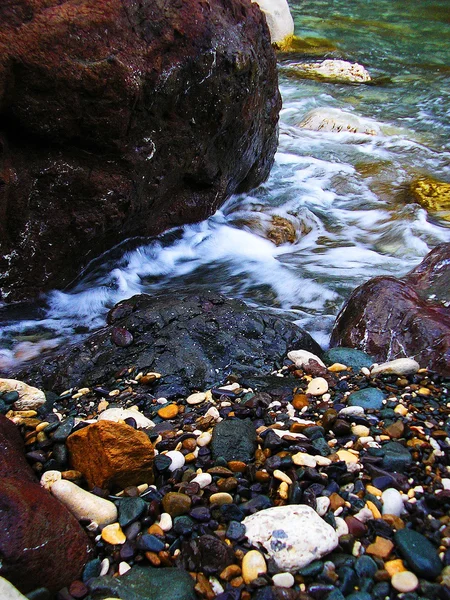 Multi-coloured wet stones on a beach — Stock Photo, Image