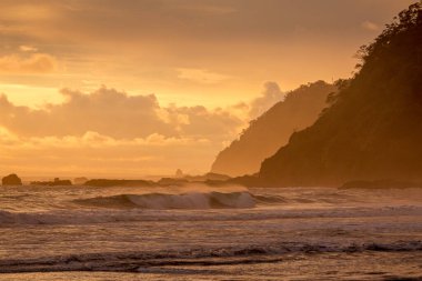 View of a sunset at the seashore, with negative space. Jaco beach in the pacific of Costa Rica. clipart