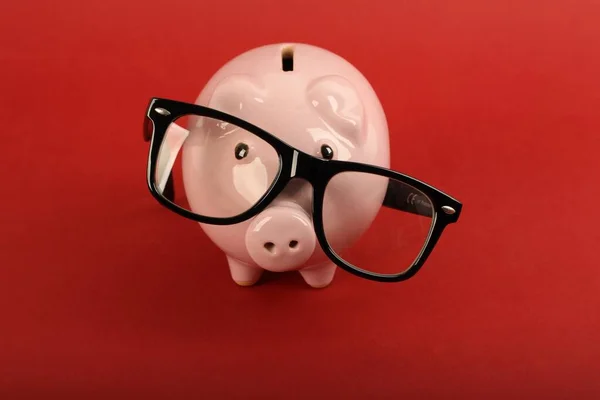 Piggy Bank Com Óculos Pretos Caindo Fundo Vermelho — Fotografia de Stock