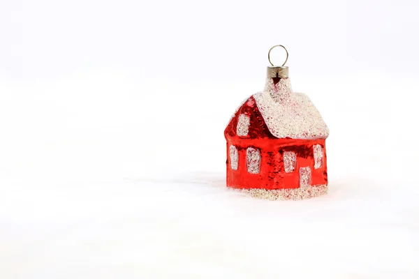 Red glossy Christmas decoration - little house standing on white fur background — Stock Photo, Image