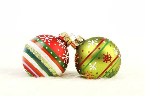 Twee kleurrijke kerstballen op wit bont achtergrond — Stockfoto