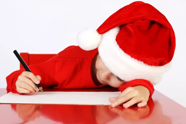 Ayudante de Navidad niño escribiendo carta a Santa Claus carta en sombrero rojo —  Fotos de Stock