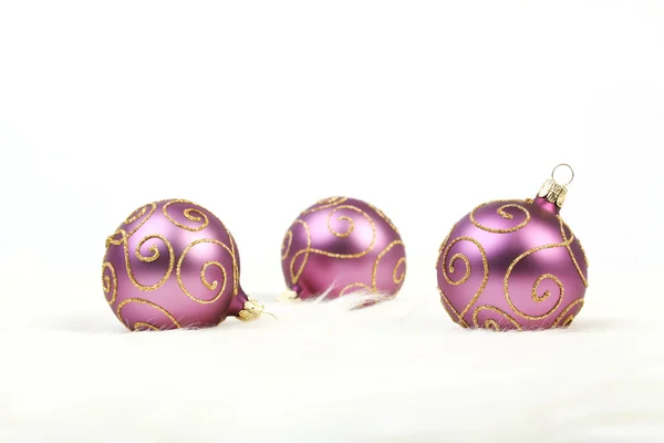 Trois boules de Noël violettes avec des lignes dorées sur fond blanc — Photo