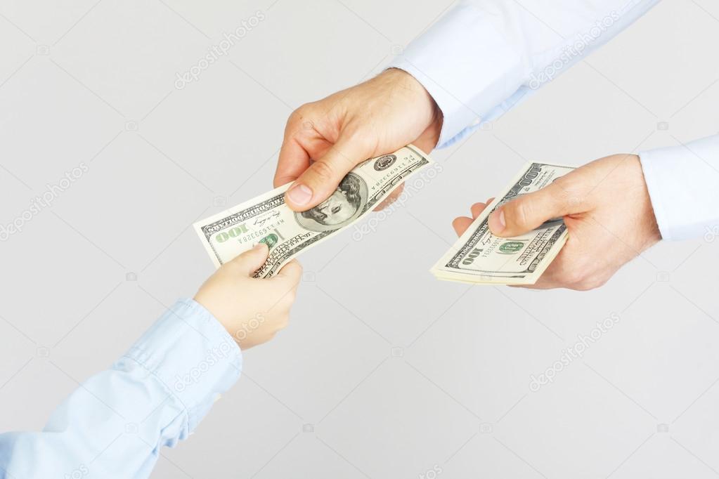 Man's hand give money american hundred dollar bills to boy hand