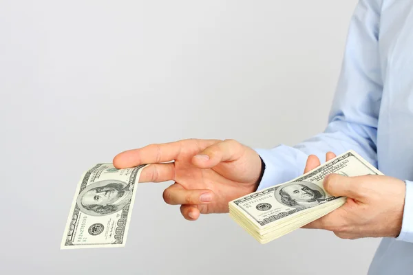 Men's hand holding money american hundred dollar bills. Hand of business man offering money. — Stock Photo, Image