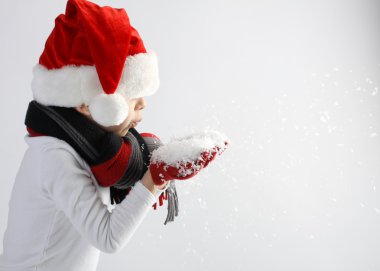 Çocuk santa claus şapka ve atkı ve eldiven kar taneleri üfleme