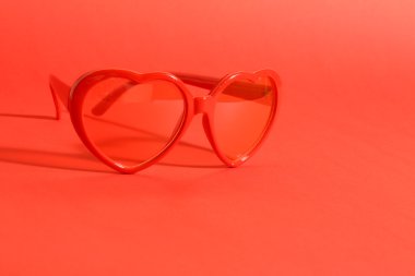 Kırmızı zemin üzerine kırmızı kalp güneş gözlüğü
