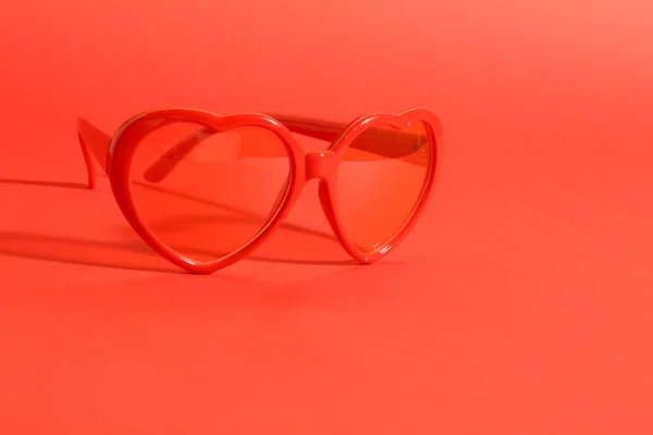 Gafas de sol corazón rojo sobre fondo rojo — Foto de Stock