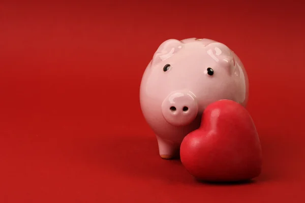 Piggy banco no amor com coração vermelho no fundo vermelho — Fotografia de Stock