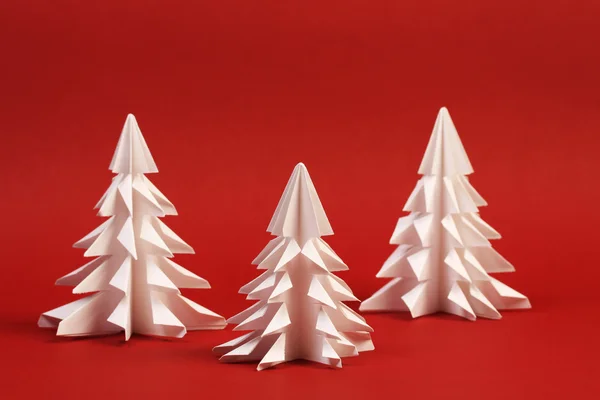 Três árvore de papel branco no fundo vermelho — Fotografia de Stock