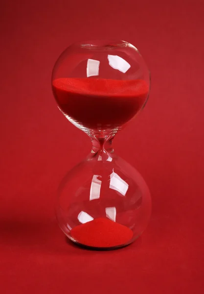 Hourglass on red background — Stock Photo, Image