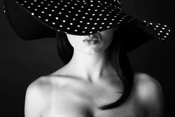 Retrato de moda de una mujer con sombrero de lunares blanco y negro y labios de puchero — Foto de Stock