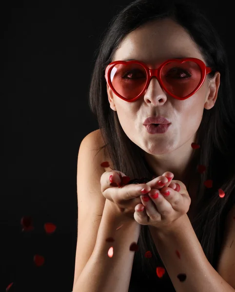 Genç ve güzel kadın kalp şeklinde gözlük ve pırıltılar kalp darbeler ile — Stok fotoğraf