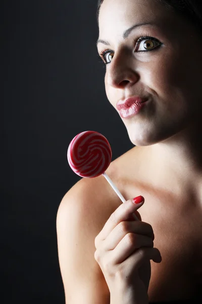 Ung och vacker kvinna med lollypop på svart bakgrund — Stockfoto