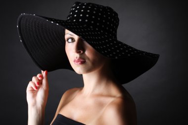 Genç ve güzel kadın şapkası siyah arka planda - yatay